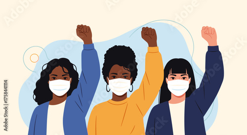 Three women wearing face masks raise their fists in protest.
