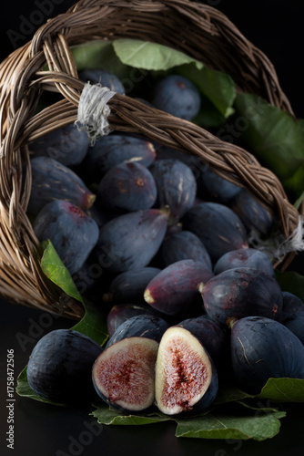 Fichi maturi in un cesto di vimini su sfondo nero
