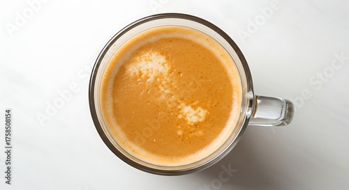 Overhead view of coffee beverage in clear glass mug on white background
