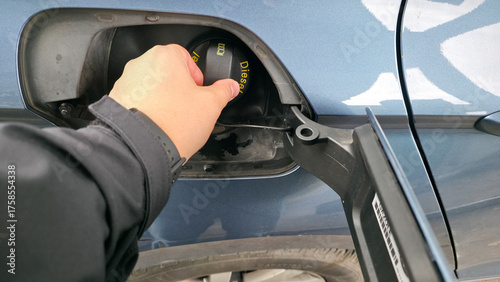 Canvas Print Hand inserting fuel nozzle into car tank