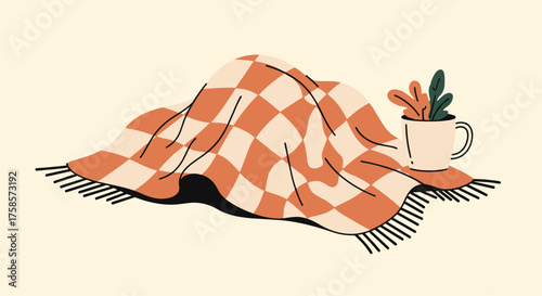 Cozy blanket draped over a mug with plant art.