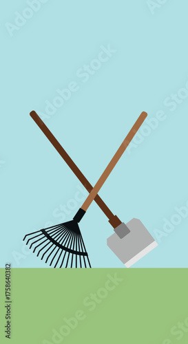Crossed rake and shovel on green grass and blue sky.