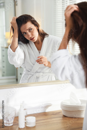 Canvas-taulu Woman with hair loss problem looking i mirror at home