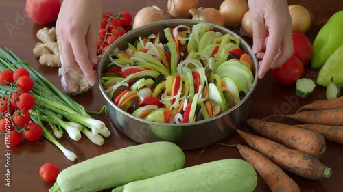 Rotation move Vegan french tian 4K. Assembling a Traditional French vegetable seasonal ratatouille casserole. Harvest festival autumn dish. Onions zucchini, eggplant, tomatoes, peppers arranged circle