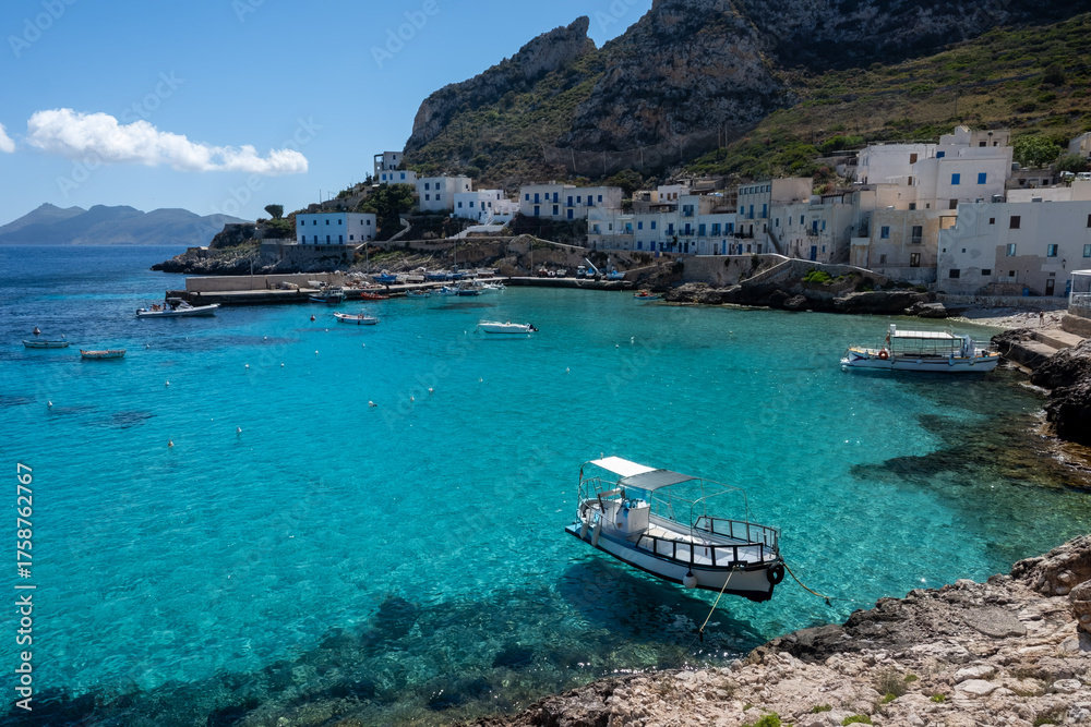 Fototapeta premium Levanzo, smallest of Egadi Islands, tranquil retreat near Sicily, picturesque village around harbor, white houses and charming blue-water harbor, travel destination, boat trip