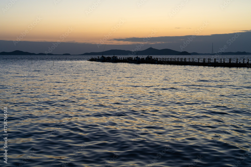 Obraz premium tranquil seascape with the pier after sunset
