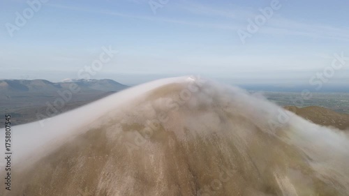 Amazing 4K aerial video of flying above and around Most Famous mountain in Ireland - Croagh Patrick in windy weather, with moving fog and clouds with breathtaking views around, Westport, Ireland