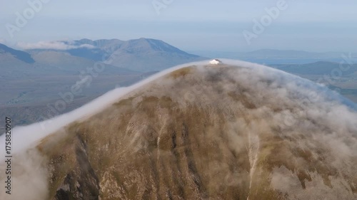 Amazing 4K aerial video of flying above and around Most Famous mountain in Ireland - Croagh Patrick in windy weather, with moving fog and clouds with breathtaking views around, Westport, Ireland