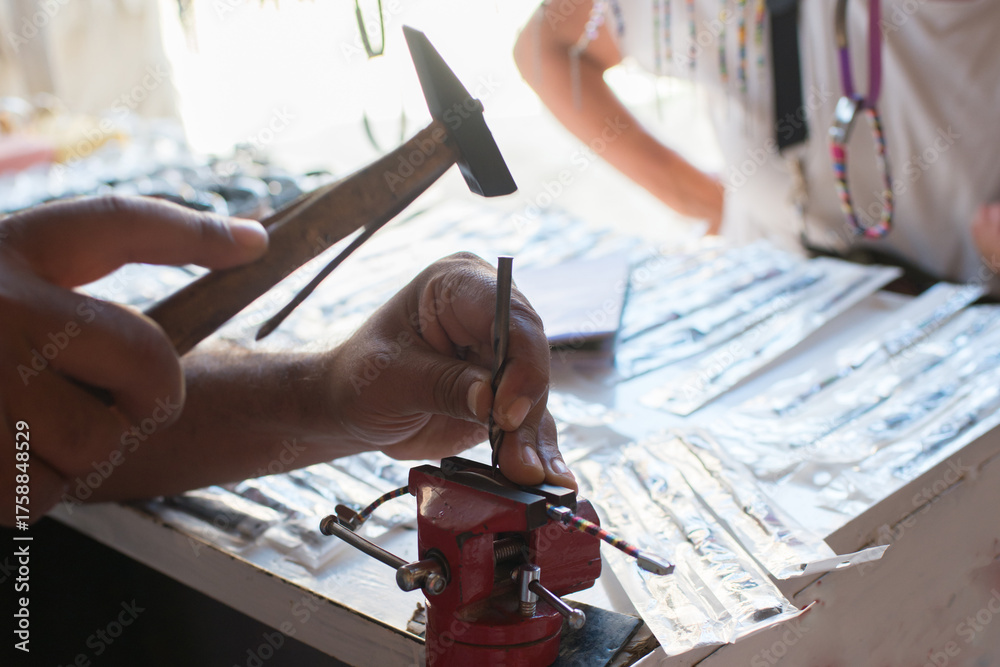 Fototapeta premium Close up of unrecognizable person holding a hammer and working with metal. Tunisia