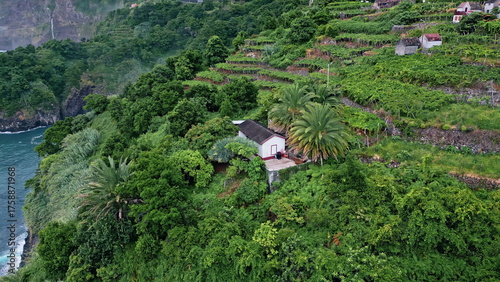 Tableau sur toile Lonely house standing greenery hill at oceanside aerial view