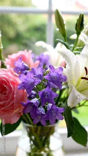 Close up of white lily flowers with water droplets near window