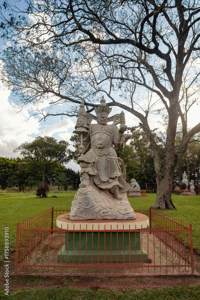 Obraz premium Impressive stone statue of Vaisravana (Kuvera), the Heavenly King and protector of the North, holding his pagoda at the Chen Tien Buddhist Temple in Foz do Iguacu, Brazil.
