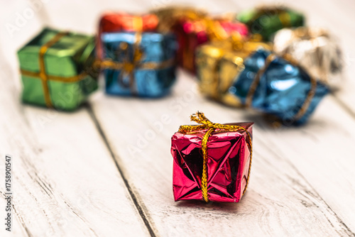 Colorful wrapped gifts arranged on a wooden surface, creating a festive atmosphere. Ideal for holiday themes, celebrations, and gift-giving occasions.