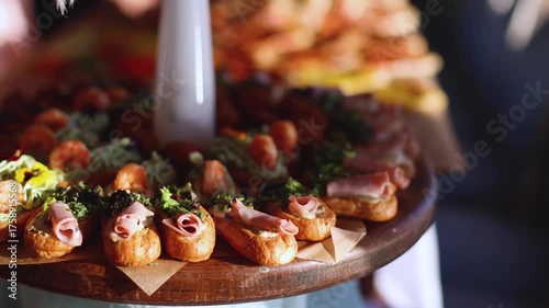 Beautifully decorated banquet catering table, with variety of with different food snacks appetizers on corporate birthday party event or wedding celebration, canape, salad, delicatessen setting
