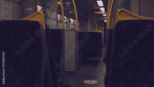 Cinematic view inside a moving train carriage with empty seats and warm sunlight streaming through the window. The screen shows upcoming stops. Peaceful travel atmosphere, perfect for lifestyle and jo