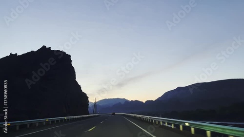 vehicle traveling on dark winding mountainous road in xinjiang, china