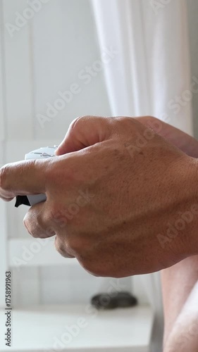 Man playing video games with a controller at home.Vertical video