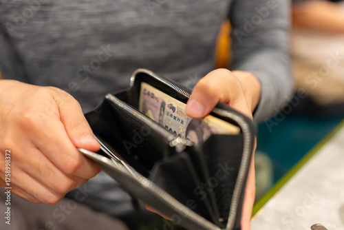 財布からお金を出す男性