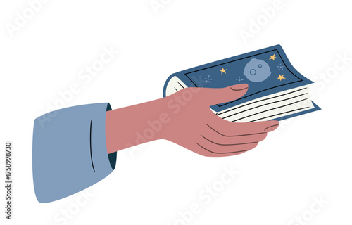 Hand holding a paper novel with blue cover with stars and asteroid. Concept of reading culture, study, and literature appreciation. Adventure book.