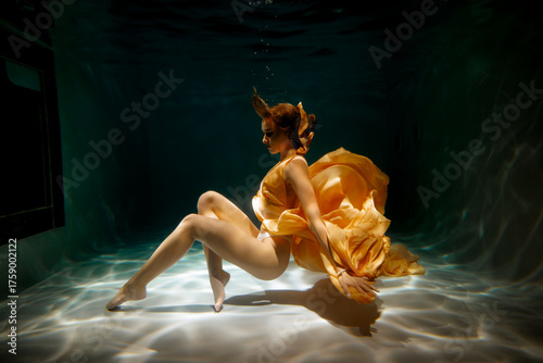 Underwater Elegance A Beautiful Lady in a Flowing Golden Dress Captivating All Around Her