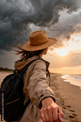 Caucasian young woman holding hand on stormy beach