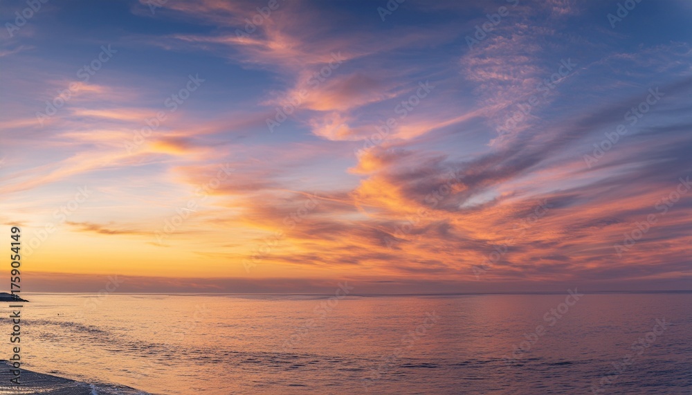 Obraz premium Morning sky with glowing cirrus clouds over calm ocean water at sunrise 