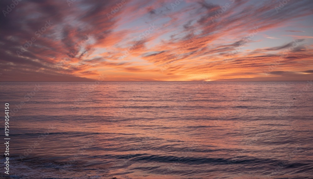 Fototapeta premium Morning sky with glowing cirrus clouds over calm ocean water at sunrise 