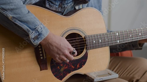 Man Playing Acoustic Guitar in Denim Jacket Indoors