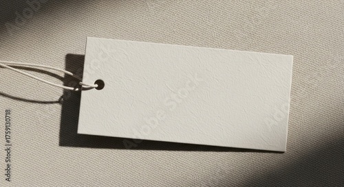 Blank tag on neutral fabric with sunlight for branding and merchandise mockups