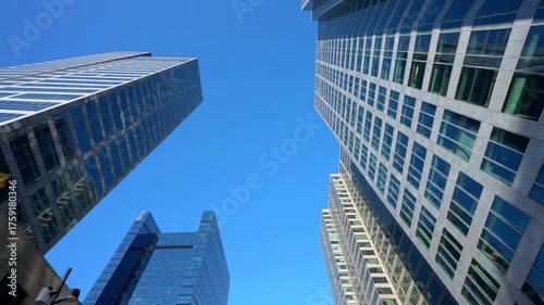 A perspective of multiple tall glass buildings against a clear blue sky
