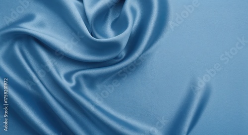 Whispers of Silk: Draped elegantly, a gentle blue silk fabric invites touch, its graceful folds catching the light and hinting at exquisite luxury.
