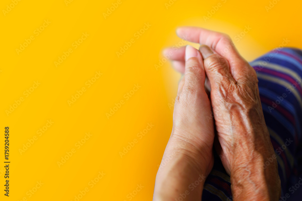 Fototapeta premium Elderly hands holding hands with younger people, through hole in yellow paper background. Art collage digital pop modern art