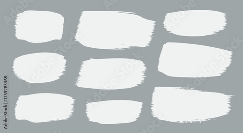 Collection of nine artistic white brush stroke shapes presented on a smooth gray background
