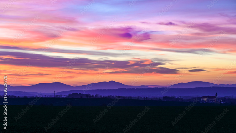 Obraz premium A stunning sunset over the Czech countryside, with colorful fields and a vibrant night sky emerging. Perfect for landscape photography, rural scenery, and dramatic sky compositions.