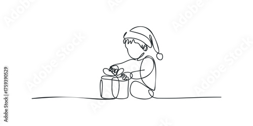 Child in Santa hat unwrapping a gift