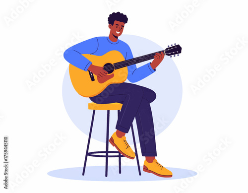 A smiling man with dark skin plays an acoustic guitar while sitting on a stool.