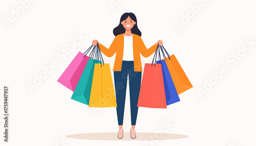 A smiling woman stands holding many colorful shopping bags in her hands.