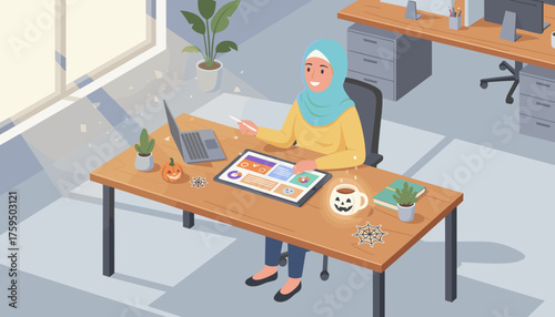 Smiling woman in hijab designs on tablet at office desk celebrating Halloween spirit