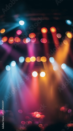 Vibrant stage lighting with beams of color shining through the concert crowd.