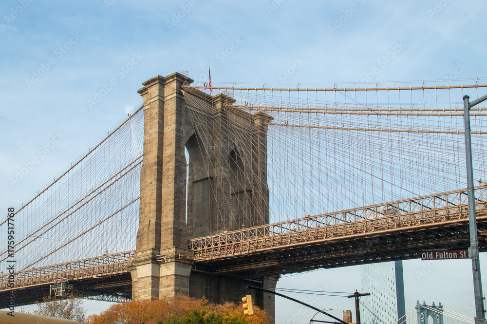 Fototapeta premium Brooklyn Bridge desde el cruce de la calle Fulton con la calle Furman. Detalles arquitectónicos del icónico puente que conecta Brooklyn y Manhattan en Nueva York, USA. 11 de noviembre de 2019.