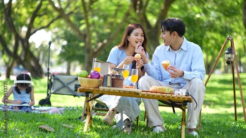Happy asian family picnic in park, weekend lifestyle outdoors.