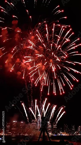 Capturing a Vibrant Red Fireworks Display Over the City at Night.