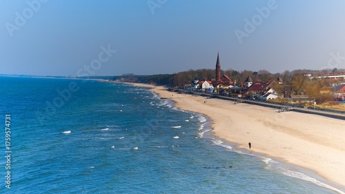 Fototapeta Naklejka Na Ścianę i Meble -  Aerial panorama of Sarbinowo’s coast, town and beach on a bright March day.