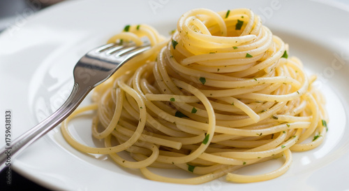 Elegant plating of plain spaghetti with herbs on a white dish.
A classic, eye-level close-up shot showcasing a beautifully plated serving of simple spaghetti