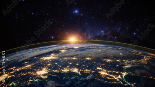 Sunrise over earths horizon, illuminating city lights below satellite