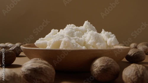Wooden plate filled with shea butter and nuts, styled for cosmetic skincare branding video concept.