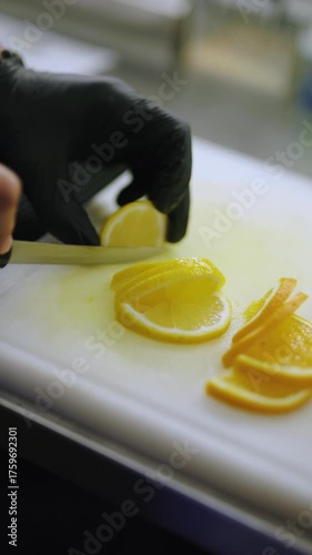Bartender hands cuts lemon into a slices, vertical video
