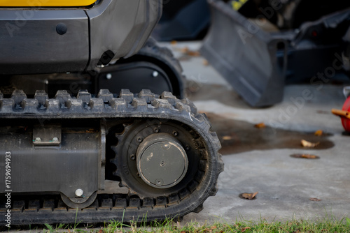 фотографія Compact excavator track detail on concrete surface, showing industrial strength,