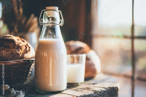 Glass Bottle of Fresh Milk and Crusty Loaves of Bread on a Rustic Wooden Table