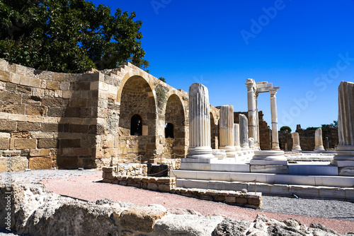 Exploring Ancient Architecture: A Journey Through Historical Ruins with Towering Columns and Arched Structures Under a Clear Blue Sky
